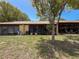Backyard view with a screened-in patio and a large tree for shade at 8320 High Point Cir # 5, Port Richey, FL 34668