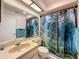 Bathroom features a decorative mirror, tiled countertop, and a forest-themed shower curtain at 8320 High Point Cir # 5, Port Richey, FL 34668