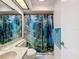 Bathroom features a decorative mirror, tiled countertop, and a forest-themed shower curtain at 8320 High Point Cir # 5, Port Richey, FL 34668