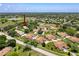 Aerial view of the villa community with a lake, showcasing the well-maintained grounds and mature trees at 8320 High Point Cir # 5, Port Richey, FL 34668