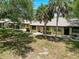 Inviting single-story villa with a lush green lawn and mature palm trees at 8320 High Point Cir # 5, Port Richey, FL 34668