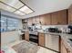 Cozy kitchen features wood cabinetry, stainless steel appliances, granite countertops, tile flooring, and natural light at 8320 High Point Cir # 5, Port Richey, FL 34668