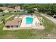 Community pool with an outdoor clubhouse, plenty of lounge chairs, tables, and umbrellas at 8320 High Point Cir # 5, Port Richey, FL 34668