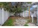 Backyard featuring a spacious storage shed, mature shade tree, and secure fencing at 8401 Pinewood St, Tampa, FL 33615
