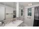 Bright bathroom with mirrored cabinet, neutral tile, and patterned shower curtain at 8401 Pinewood St, Tampa, FL 33615
