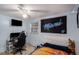 Well-lit bedroom with a ceiling fan, gaming station, and light-colored walls at 8401 Pinewood St, Tampa, FL 33615