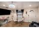 Bright dining room with a glass table, four white chairs, stylish chandelier, and a large screen TV at 8401 Pinewood St, Tampa, FL 33615