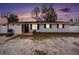 Charming single-story home at dusk with a basketball hoop and fenced yard, offering comfortable living at 8401 Pinewood St, Tampa, FL 33615
