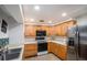 Well-lit kitchen features wooden cabinetry, stainless steel appliances, and functional design at 8401 Pinewood St, Tampa, FL 33615