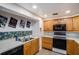 Efficient kitchen with wooden cabinetry, a black oven, stainless steel sink, and bright lighting at 8401 Pinewood St, Tampa, FL 33615