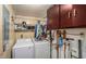 Functional laundry room with white washer and dryer, ample storage cabinets and useful shelving at 8401 Pinewood St, Tampa, FL 33615