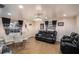 Cozy living room features a glass table, comfortable black sofas, modern lighting, and neutral-toned walls at 8401 Pinewood St, Tampa, FL 33615