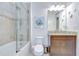 Tiled bathroom featuring a shower-tub combo, granite countertop, and wood vanity at 8433 Alberata Vista Dr, Tampa, FL 33647