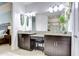 Bright bathroom featuring granite countertops, double sinks, dark wood cabinetry, and decorative wall art at 8433 Alberata Vista Dr, Tampa, FL 33647