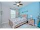 Charming bedroom featuring a wooden bed frame, beachy decor, and light blue accent wall at 8433 Alberata Vista Dr, Tampa, FL 33647
