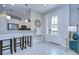 Modern entryway with white tiled floors, view of kitchen, and decorated console table at 8433 Alberata Vista Dr, Tampa, FL 33647