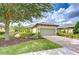 Charming home featuring a tile roof, two-car garage, brick paver driveway, and lush landscaping at 8433 Alberata Vista Dr, Tampa, FL 33647