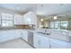 Bright kitchen boasts white cabinets, stainless steel appliances, tile backsplash and granite countertops at 8433 Alberata Vista Dr, Tampa, FL 33647