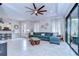 Bright living room with tiled floors, ceiling fan, large couch, and sliding glass doors at 8433 Alberata Vista Dr, Tampa, FL 33647