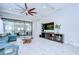 Bright and airy living room featuring tiled floors, entertainment center and view of screened porch at 8433 Alberata Vista Dr, Tampa, FL 33647