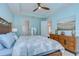 Light and airy bedroom features a wooden bed frame, ceiling fan and ensuite access at 8433 Alberata Vista Dr, Tampa, FL 33647