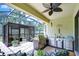 Outdoor kitchen features a grill, stainless steel appliances, and bar seating under screened enclosure at 8433 Alberata Vista Dr, Tampa, FL 33647
