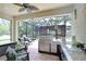 Spacious outdoor kitchen features a grill, stainless steel appliances, bar seating, and screened enclosure at 8433 Alberata Vista Dr, Tampa, FL 33647