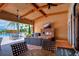 Relaxing outdoor patio with fireplace, TV, and comfortable seating overlooks the community pool at 8433 Alberata Vista Dr, Tampa, FL 33647