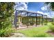 View of the screened patio with an outdoor kitchen, a grilling area, and a seating area at 8433 Alberata Vista Dr, Tampa, FL 33647