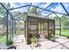 Beautiful screened patio featuring brick floors, modern pergola, plants, and comfortable seating area at 8433 Alberata Vista Dr, Tampa, FL 33647