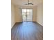 A spacious room with dark wood flooring and sliding glass door leading to a small balcony at 850 S Tamiami Trl # 424, Sarasota, FL 34236