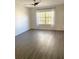 A bedroom with gray wood flooring and a large window for natural light at 850 S Tamiami Trl # 424, Sarasota, FL 34236