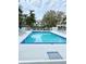 Outdoor swimming pool with lounge chairs surrounded by tropical landscaping and community buildings at 850 S Tamiami Trl # 424, Sarasota, FL 34236