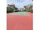 Red and green tennis court with spectator benches in a lush landscaped community at 850 S Tamiami Trl # 424, Sarasota, FL 34236