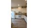 Open kitchen with white cabinets, modern appliances, and vinyl flooring at 8814 Walnut Gable Ct, Riverview, FL 33578