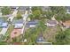 A high aerial shot shows a home with solar panels surrounded by green lawns and lush trees at 919 Alpine Dr, Brandon, FL 33510