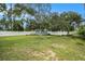 Large grassy backyard with mature trees, playground, shed, and privacy fence at 919 Alpine Dr, Brandon, FL 33510