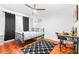 This bedroom has sleek wood floors, a ceiling fan, and a modern black and white color scheme at 9481 Highland Oak Dr # 1504, Tampa, FL 33647