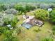 An aerial view of the home and outbuildings set on a treed lot at 9615 Raiden Ln, Riverview, FL 33569