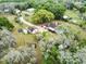 An aerial view of the treed property showcasing the main home and outbuildings at 9615 Raiden Ln, Riverview, FL 33569