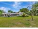 View of the grassy backyard showcasing a pool and screened enclosure at 9615 Raiden Ln, Riverview, FL 33569