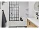 Modern bathroom showcasing a bathtub with black-framed glass shower screen and open shelving at 9615 Raiden Ln, Riverview, FL 33569