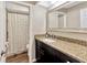 Bathroom vanity featuring granite countertop, dark wood cabinetry, and large decorative mirror at 9615 Raiden Ln, Riverview, FL 33569