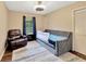 Cozy bedroom featuring a tufted daybed, armchair, dark wood floors and a window at 9615 Raiden Ln, Riverview, FL 33569