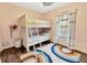 Charming bedroom featuring a bright bunk bed, a colorful rug, and a sunlit window at 9615 Raiden Ln, Riverview, FL 33569