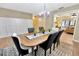 Dining room featuring wood table and chairs with modern chandelier and decorative rug at 9615 Raiden Ln, Riverview, FL 33569