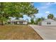 Home with a detached garage featuring a long driveway, lush lawn, and shade trees at 9615 Raiden Ln, Riverview, FL 33569