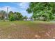 Expansive front yard featuring mature trees and a view of the charming home at 9615 Raiden Ln, Riverview, FL 33569