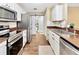 Updated kitchen featuring stainless appliances, tiled backsplash, hardwood flooring, and a sliding barn door at 9615 Raiden Ln, Riverview, FL 33569