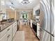 A kitchen with stainless steel appliances, dark countertops, and hardwood floors, with a dining area beyond at 9615 Raiden Ln, Riverview, FL 33569